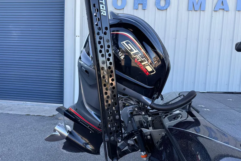 Slide: The Image of 2023 Skeeter FXR20 Select boat with powerful SHOm VMAX engine, parked near a blue garage. - 5