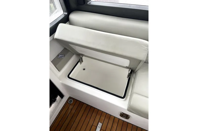 Slide: The Image of 2024 Schaefer V33 boat interior with open storage compartment and wooden flooring. - 24