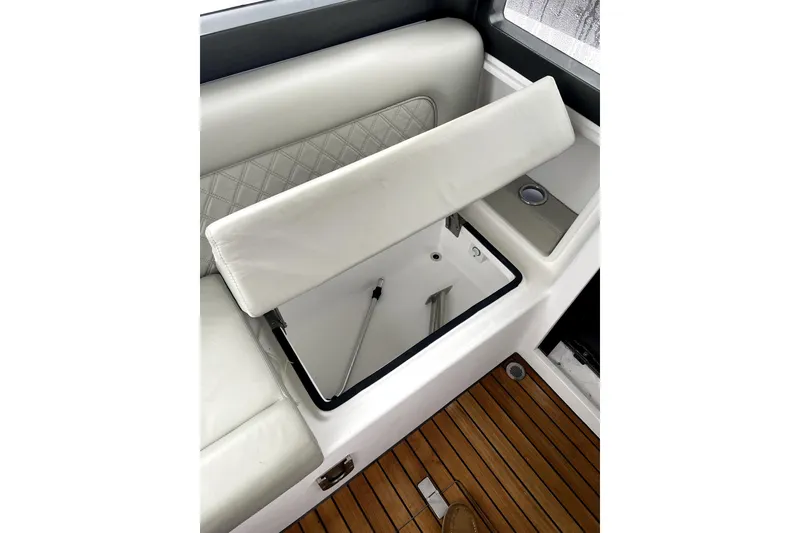 Slide: The Image of 2024 Schaefer V33 boat seat with storage compartment, featuring white upholstery and wooden flooring. - 25