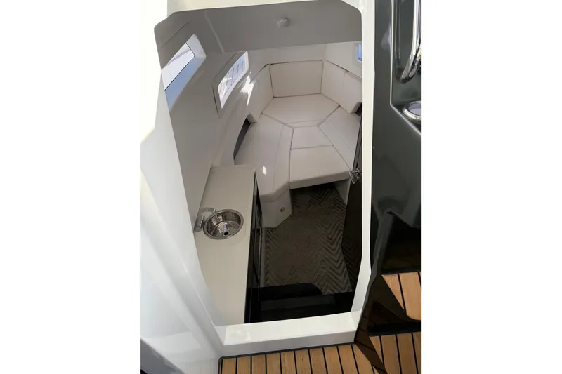 Slide: The Image of 2024 Schaefer V33 cabin interior with white seating and compact sink. - 26