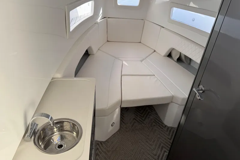 Slide: The Image of 2024 Schaefer V33 yacht interior with white seating and compact sink. - 27