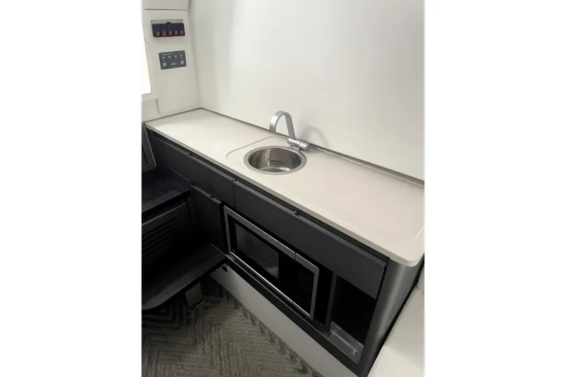 Slide: The Image of 2024 Schaefer V33 yacht kitchenette with sink, microwave, and control panel. - 28