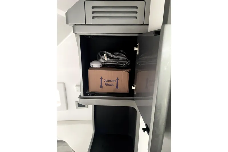 Slide: The Image of Open cabinet in 2024 Schaefer V33 boat with fragile box and items inside. - 29