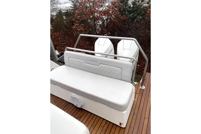 Slide: The Image of 2024 Schaefer V33 boat with dual engines, docked near a wooded area. - 5