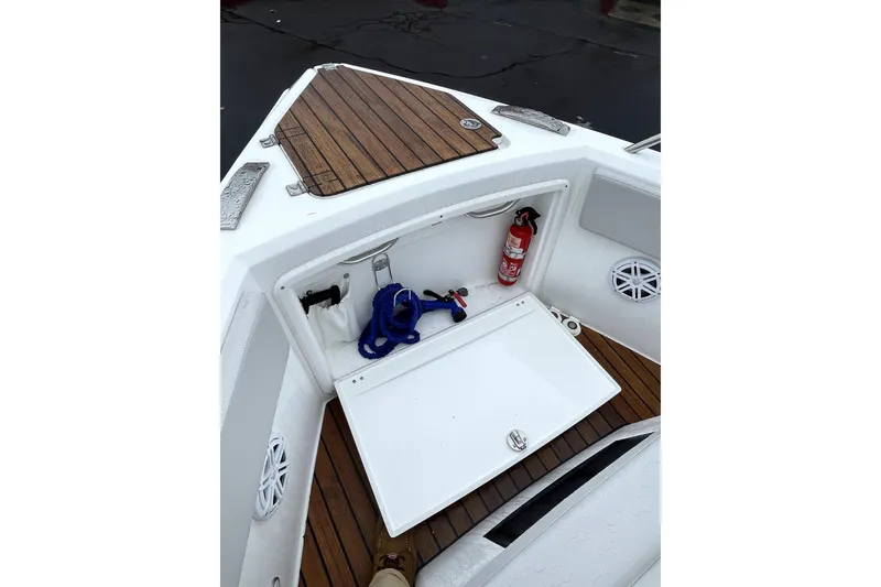 Slide: The Image of 2024 Schaefer V33 boat docked near red building, surrounded by covered boats. - 8