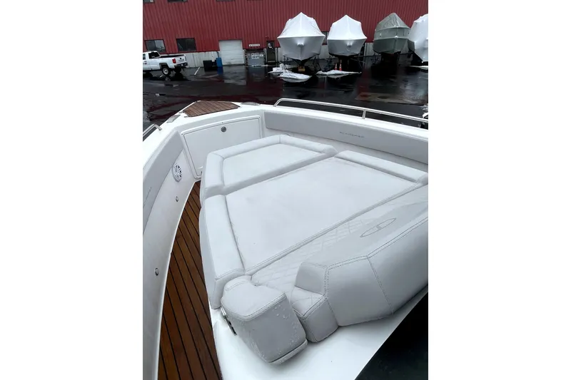 Slide: The Image of 2024 Schaefer V33 boat with cushioned seating, surrounded by covered boats in a storage area. - 9