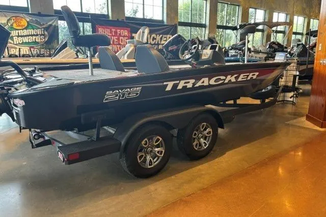 The Image of 2026 Tracker Savage 215 boat on display in a showroom, featuring sleek design and dual axles. - 0