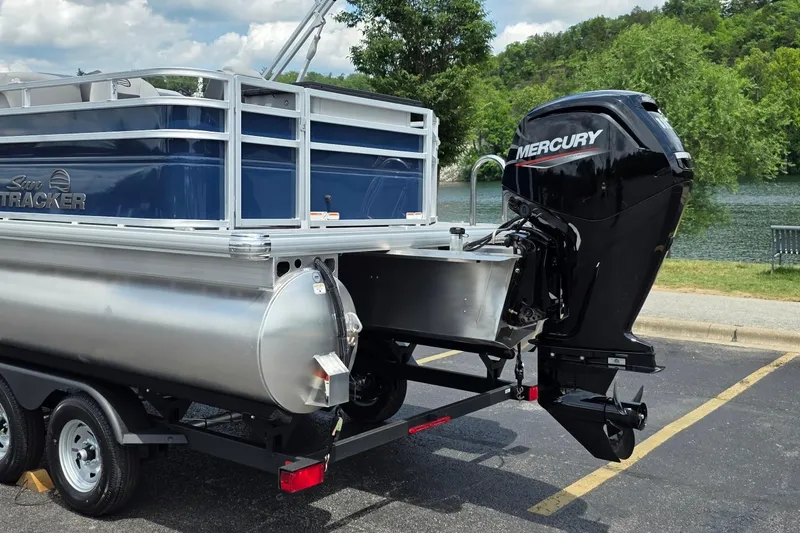 Slide: The Image of 2026 Sun Tracker SportFish 20 DLX pontoon boat with Mercury outboard motor by a lake. - 13
