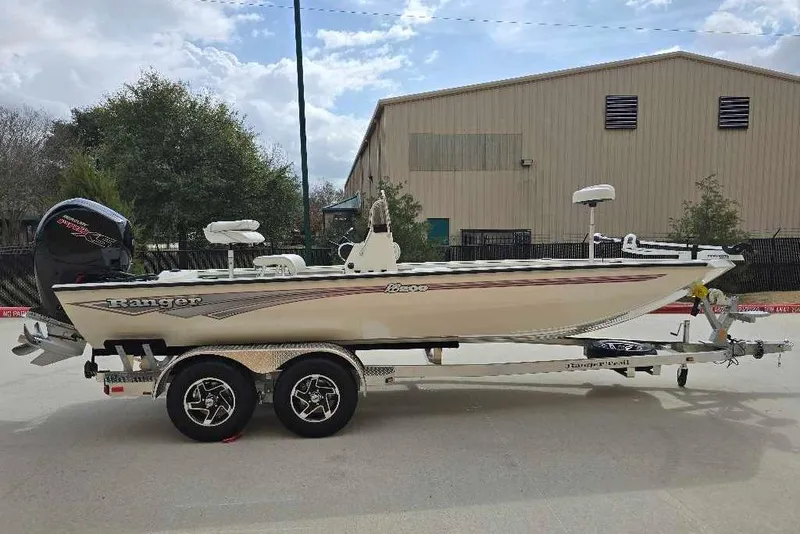 The Image of 2026 Ranger RB200 boat on trailer, parked outdoors near industrial building. - 0