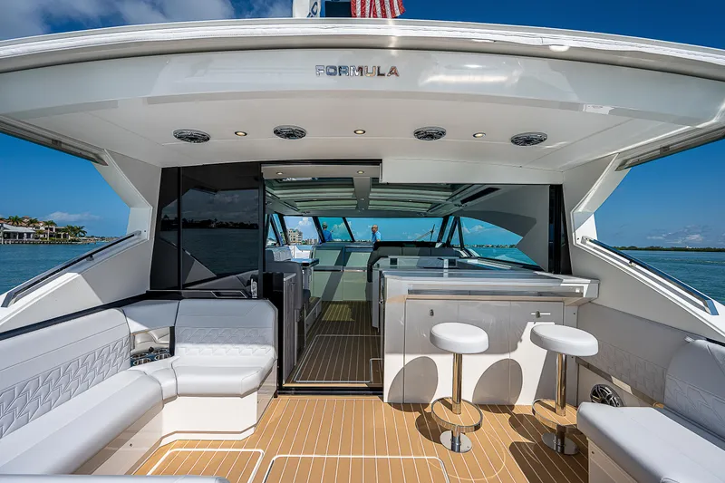 Slide: The Image of 2022 Formula 500 Super Sport Crossover yacht interior with seating and bar stools. - 12