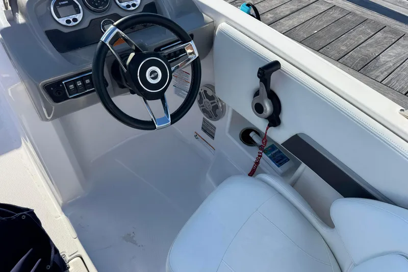 Slide: The Image of 2018 Chaparral 19 SSi Ski & Fish OB boat interior with steering wheel and controls. - 2