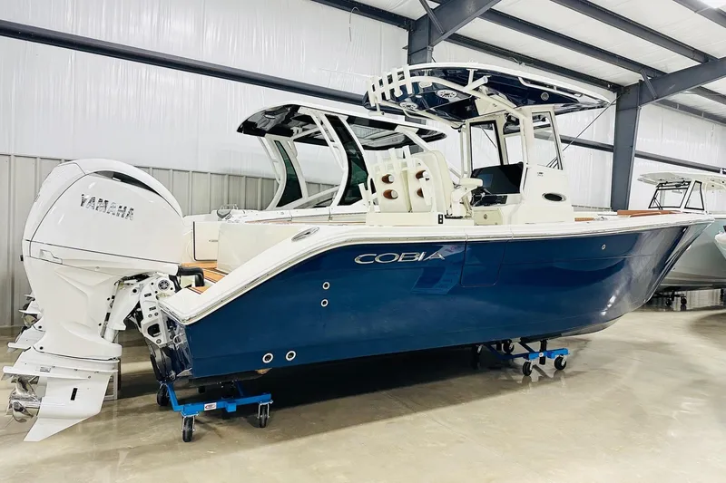 The Image of 2026 Cobia 265 Center Console boat with Yamaha engine in showroom. - 1