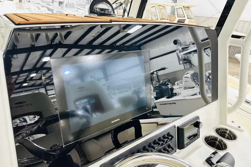 Slide: The Image of 2026 Cobia 265 Center Console dashboard with Garmin display and controls in a showroom. - 3