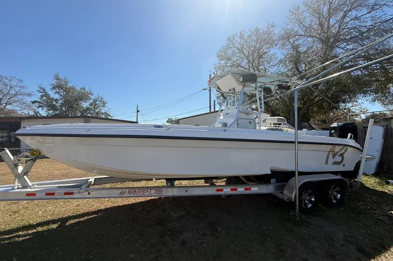 The Image of 2003 Glasstream 273 SCX boat on trailer, parked outdoors under clear sky. - 0