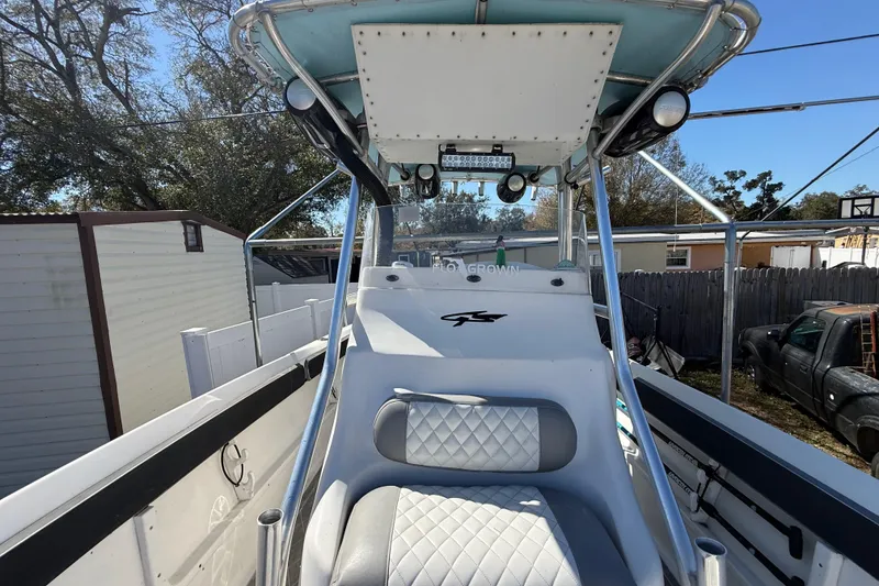 Slide: The Image of 2003 Glasstream 273 SCX boat interior with seating and canopy, parked outdoors. - 103
