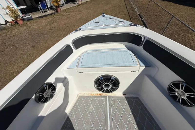 Slide: The Image of 2003 Glasstream 273 SCX boat interior with speakers and seating, docked on grass. - 108