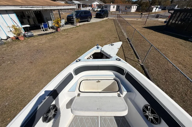 Slide: The Image of 2003 Glasstream 273 SCX boat parked in a residential yard, showing open storage compartments. - 113