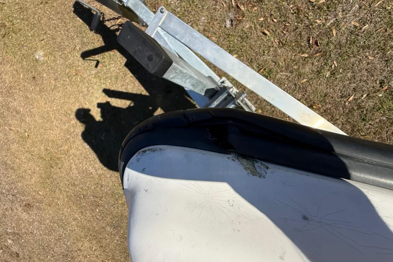 Slide: The Image of Damaged bow of 2003 Glasstream 273 SCX boat on trailer, showing wear and scratches. - 115