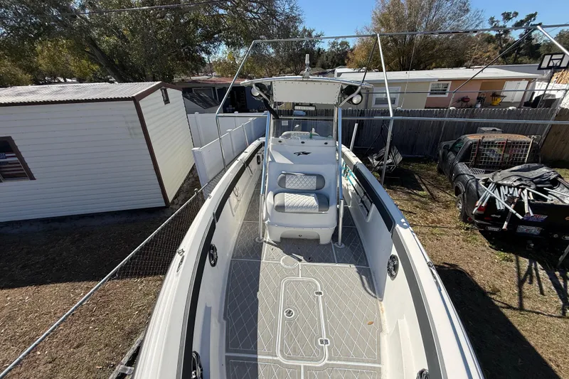 Slide: The Image of 2003 Glasstream 273 SCX boat in a backyard, featuring spacious deck and seating. - 118