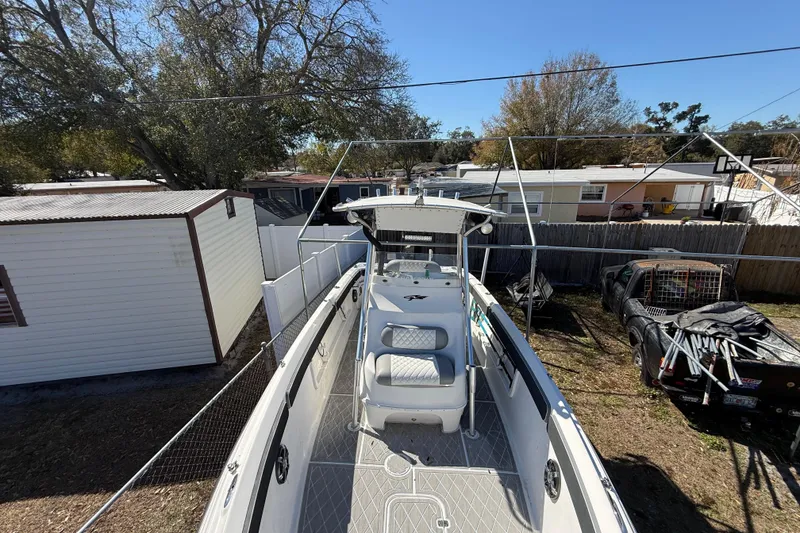 Slide: The Image of 2003 Glasstream 273 SCX boat parked outdoors, surrounded by trees and vehicles. - 119