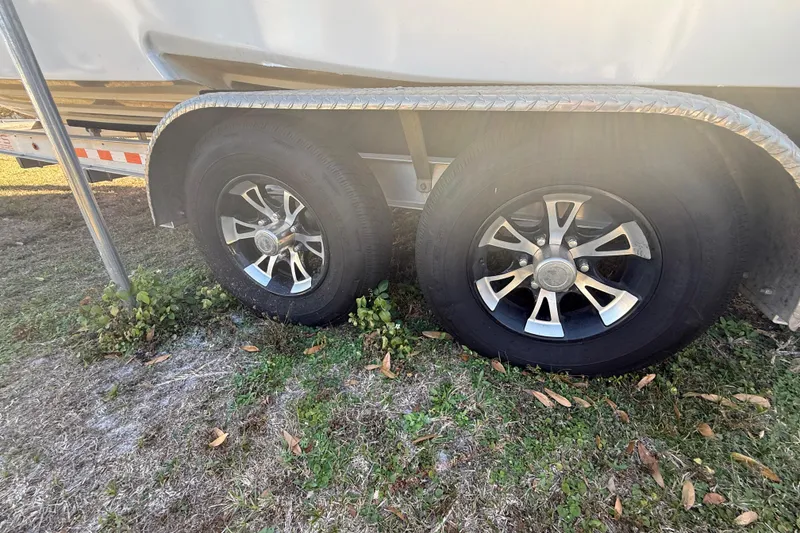 Slide: The Image of Trailer wheels of a 2003 Glasstream 273 SCX boat on grass. - 126