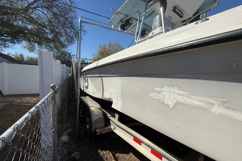 Slide: The Image of 2003 Glasstream 273 SCX boat on trailer, parked beside a fence. - 18