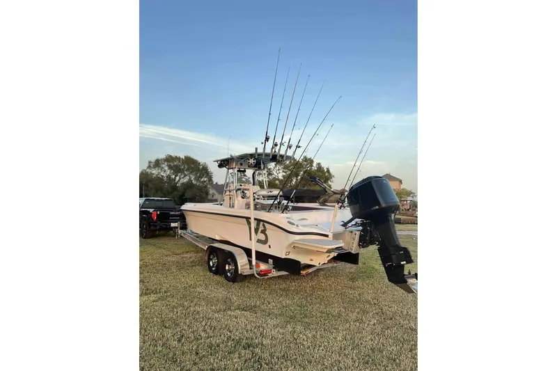 Slide: The Image of 2003 Glasstream 273 SCX boat on trailer, parked outdoors under clear sky. - 2