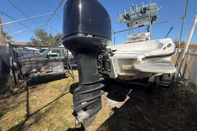 Slide: The Image of 2003 Glasstream 273 SCX boat with outboard motor in a yard setting. - 23