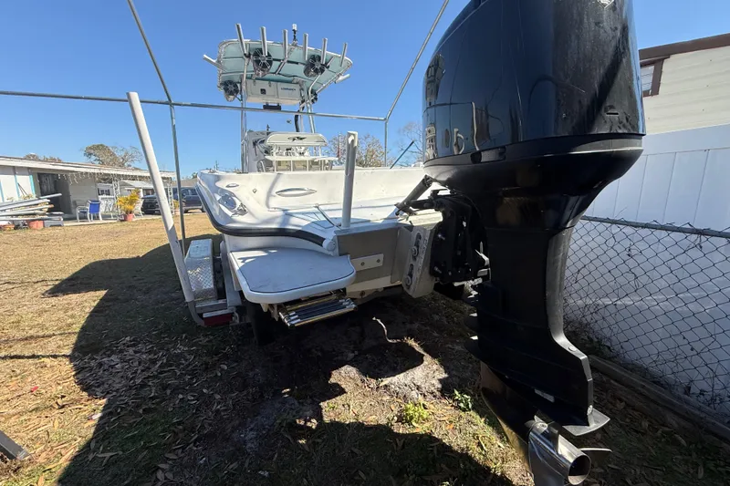 Slide: The Image of 2003 Glasstream 273 SCX boat with outboard motor on trailer in yard. - 27