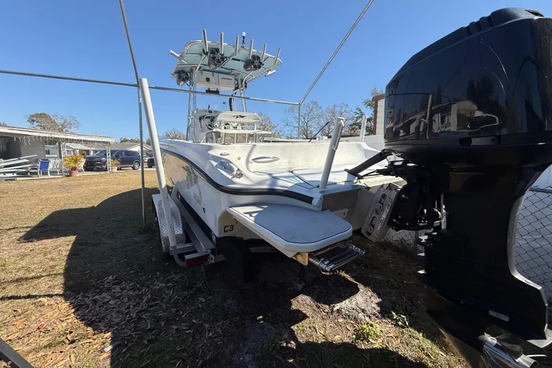 Slide: The Image of 2003 Glasstream 273 SCX boat on trailer with outboard motor, parked outdoors. - 28