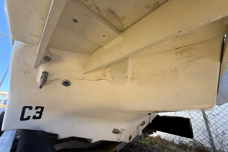 Slide: The Image of 2003 Glasstream 273 SCX boat hull underside with visible wear and hardware. - 37