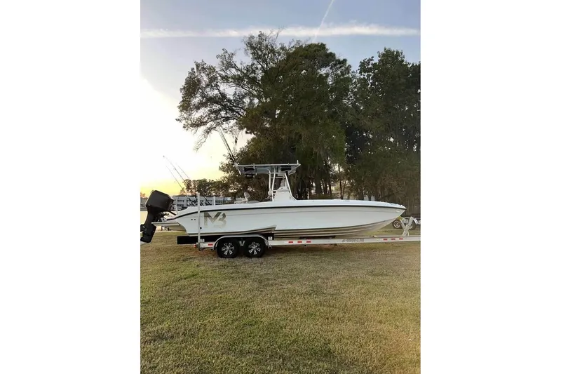 Slide: The Image of 2003 Glasstream 273 SCX boat on trailer, parked on grass under clear blue sky. - 4