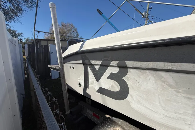 Slide: The Image of 2003 Glasstream 273 SCX boat parked beside a fence, featuring a bold "M3" logo. - 42