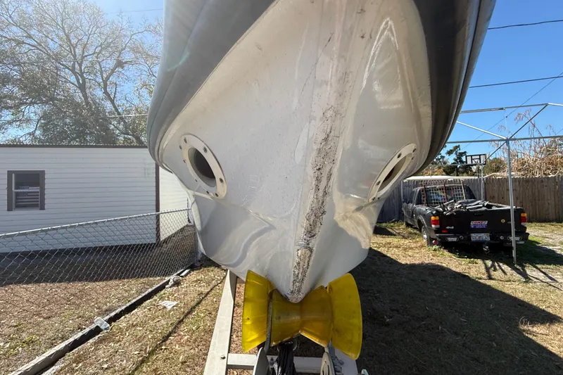 Slide: The Image of 2003 Glasstream 273 SCX boat hull with visible wear, parked outdoors. - 43