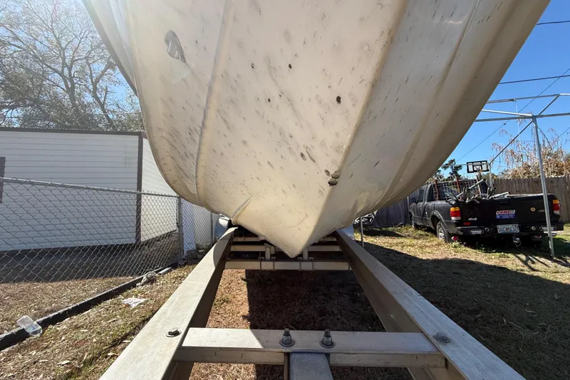 Slide: The Image of 2003 Glasstream 273 SCX boat on trailer, parked outdoors near a fence and truck. - 44