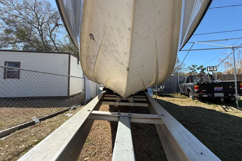 Slide: The Image of 2003 Glasstream 273 SCX boat on trailer, parked outdoors near a fence and truck. - 46
