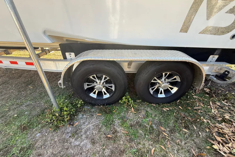 Slide: The Image of Trailer wheels of a 2003 Glasstream 273 SCX boat on grass. - 47