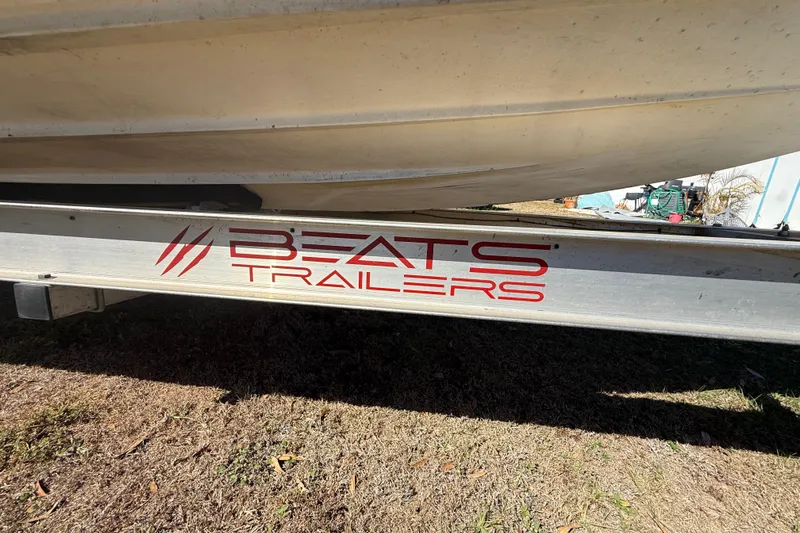 Slide: The Image of Trailer with "Beats Trailers" logo, supporting a 2003 Glasstream 273 SCX boat. - 48