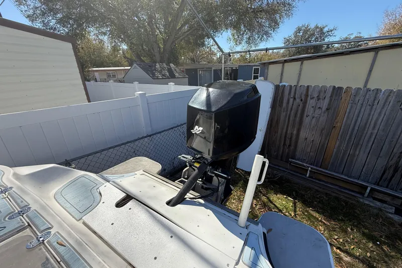 Slide: The Image of 2003 Glasstream 273 SCX boat with outboard motor in a fenced yard. - 52
