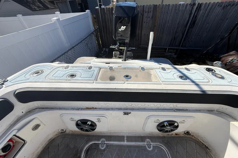 Slide: The Image of 2003 Glasstream 273 SCX boat deck with speakers and storage compartments. - 56