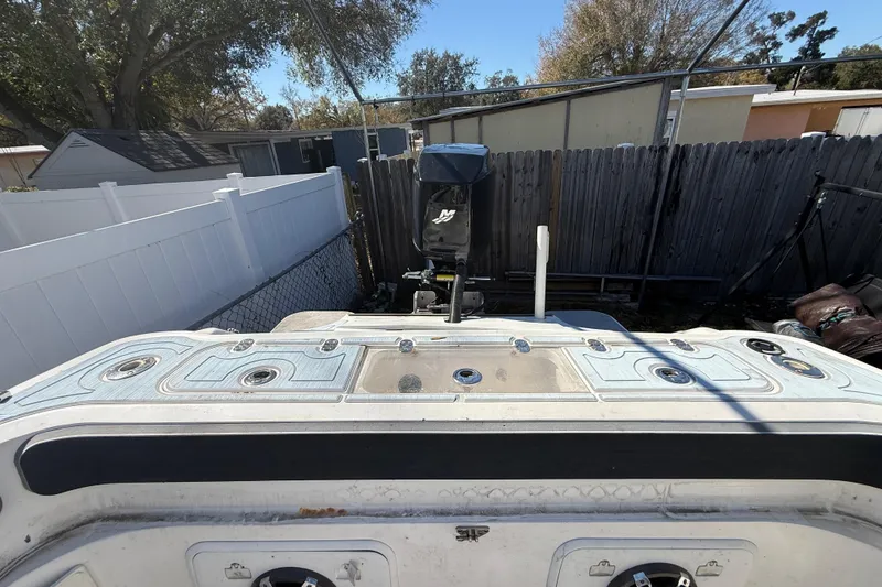 Slide: The Image of 2003 Glasstream 273 SCX boat with outboard motor in a fenced yard. - 57