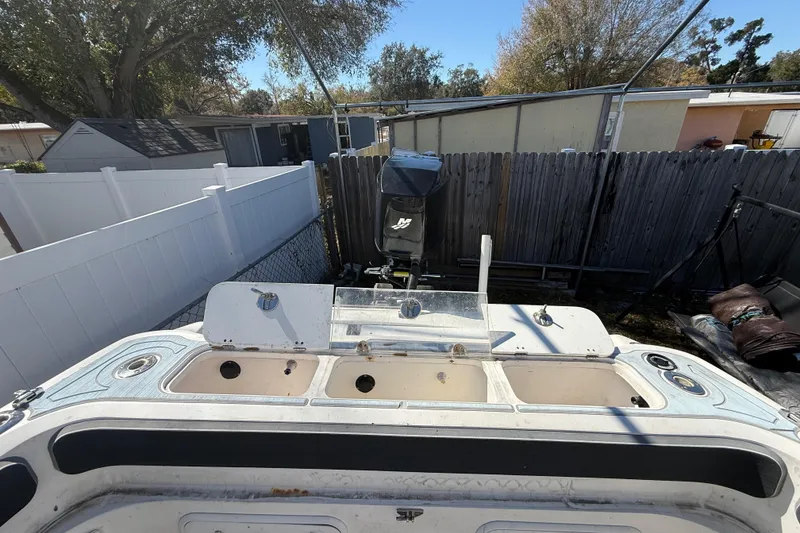 Slide: The Image of 2003 Glasstream 273 SCX boat with outboard motor in a backyard setting. - 60