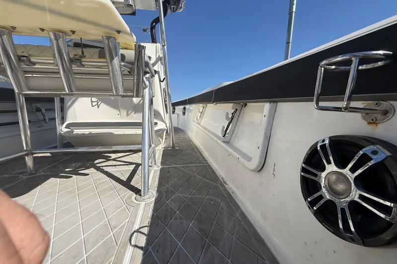 Slide: The Image of 2003 Glasstream 273 SCX boat interior with seating, speaker, and metal railings under clear sky. - 65