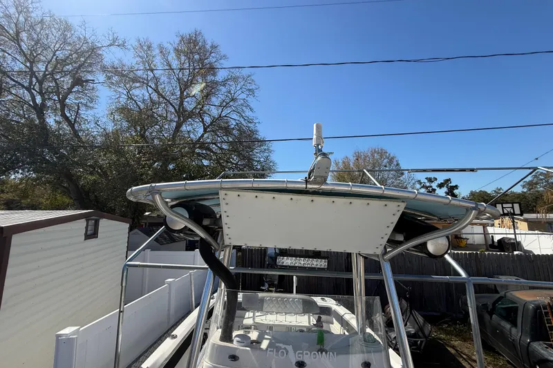Slide: The Image of 2003 Glasstream 273 SCX boat with T-top, parked outdoors under clear blue sky. - 73