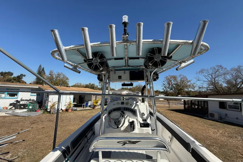 Slide: The Image of 2003 Glasstream 273 SCX boat with T-top and rod holders, parked outdoors. - 77