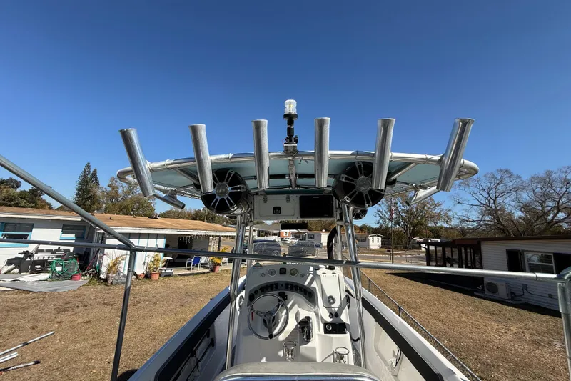 Slide: The Image of 2003 Glasstream 273 SCX boat with rod holders and control panel, parked outdoors. - 78