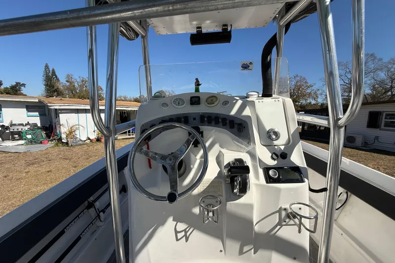 Slide: The Image of 2003 Glasstream 273 SCX boat console with steering wheel and controls, outdoor setting. - 81