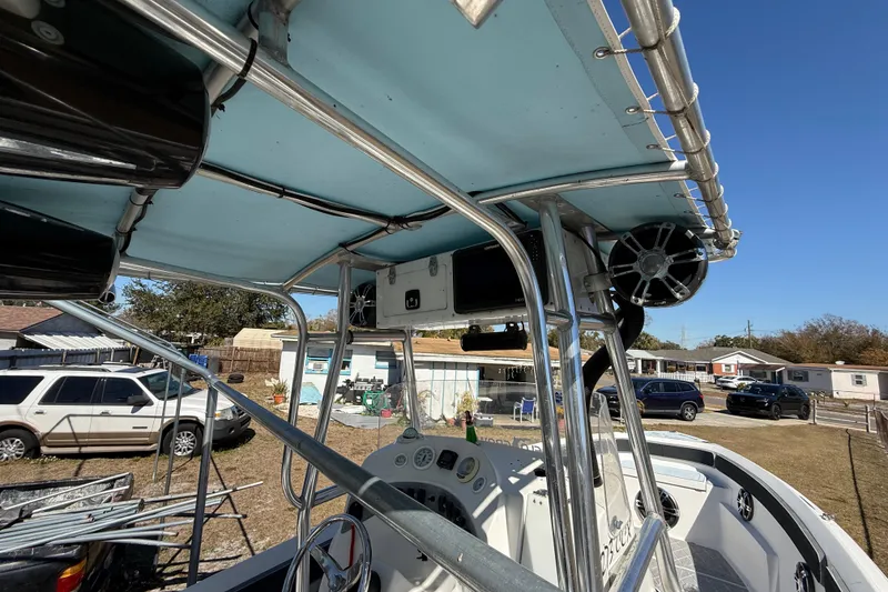 Slide: The Image of 2003 Glasstream 273 SCX boat interior with metal framework and dashboard, parked outdoors. - 91