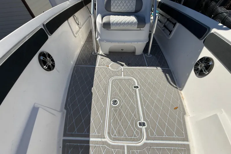 Slide: The Image of 2003 Glasstream 273 SCX boat interior with diamond-patterned flooring and cushioned seating. - 99