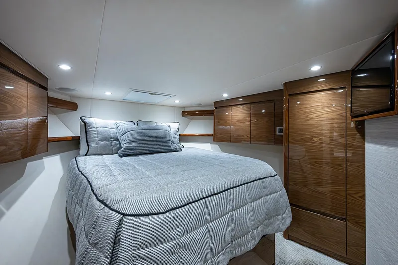 Slide: The Image of Luxurious bedroom interior of 2023 Viking 48 Sport Tower yacht with elegant wood finishes. - 14